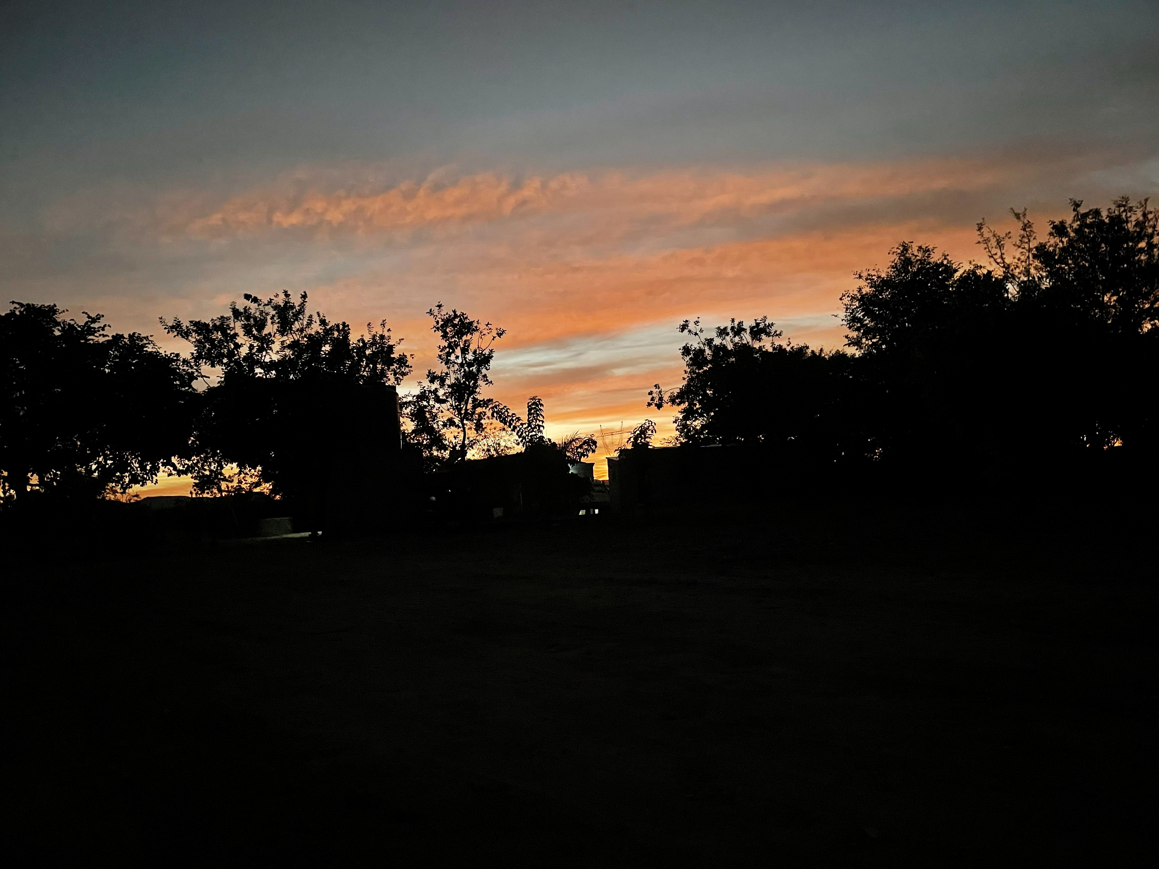 The compound silhouetted against a dry-season sunset